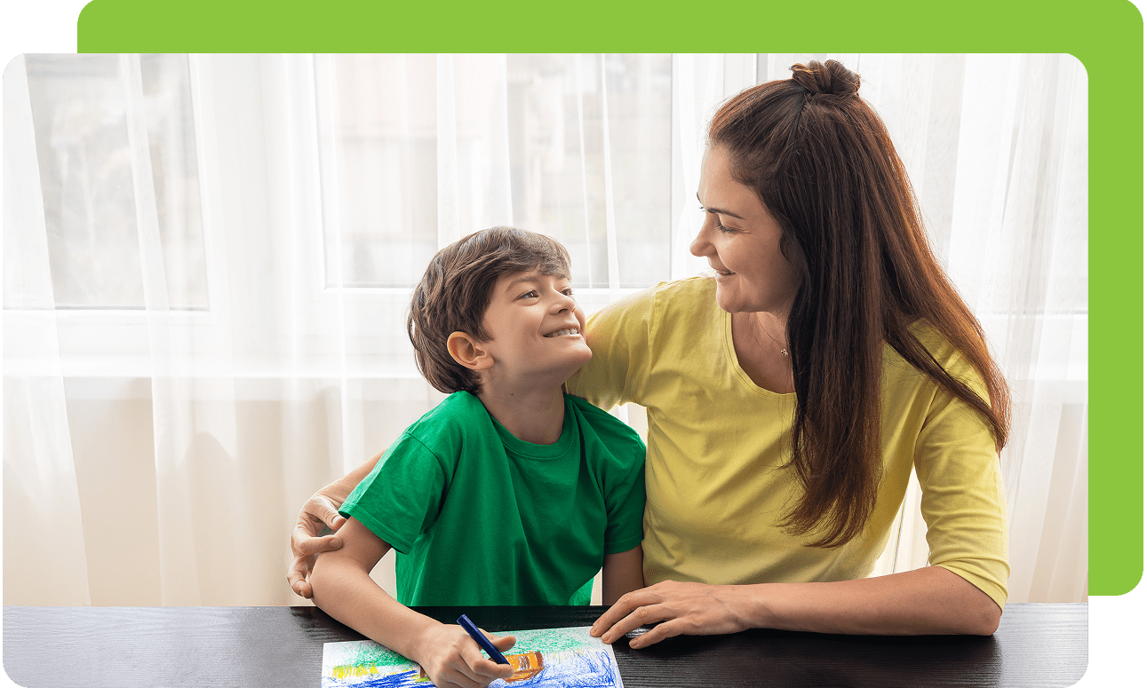 Mother and child smiling while drawing together.