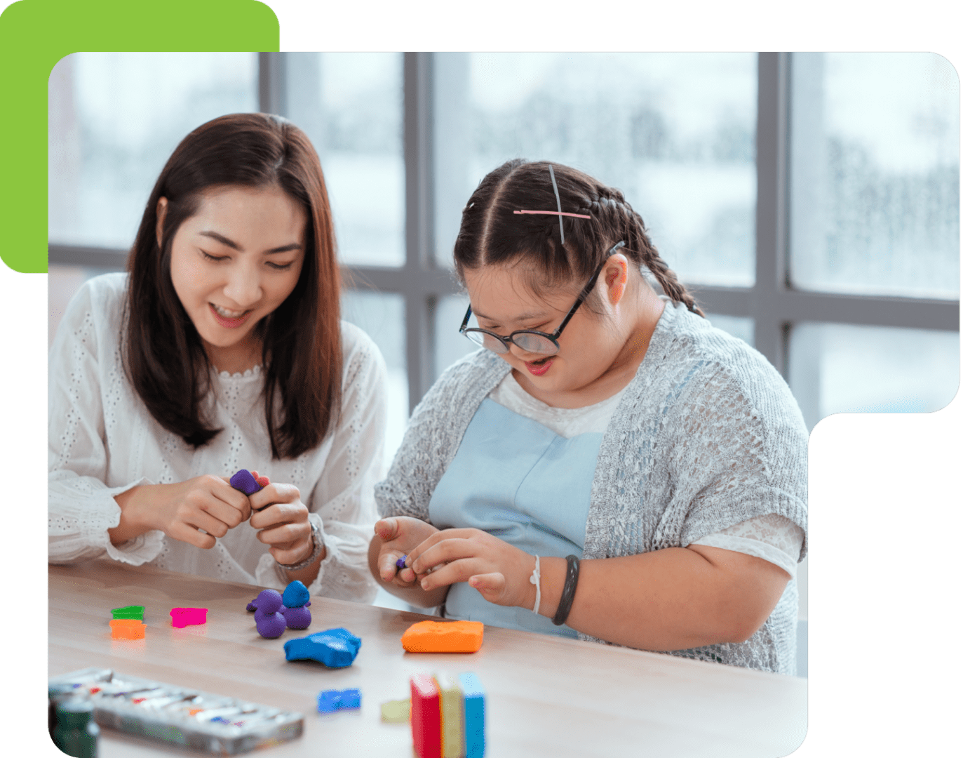 Two women crafting with colorful clay.